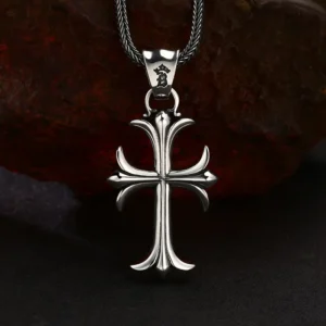 Polished 925 sterling silver gothic fleur‑de‑lis cross pendant, vintage sculpted cross charm displayed against rough rust rock background