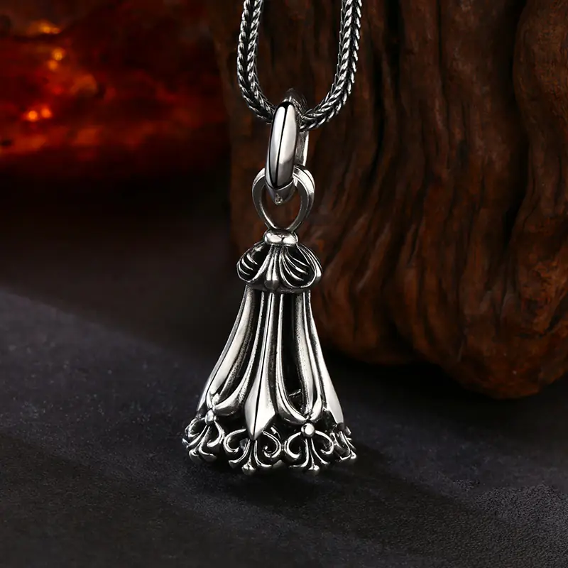 Antique oxidized 925 sterling silver tassel bell pendant, hollow filigree retro carving, gothic vintage charm against natural wood texture background