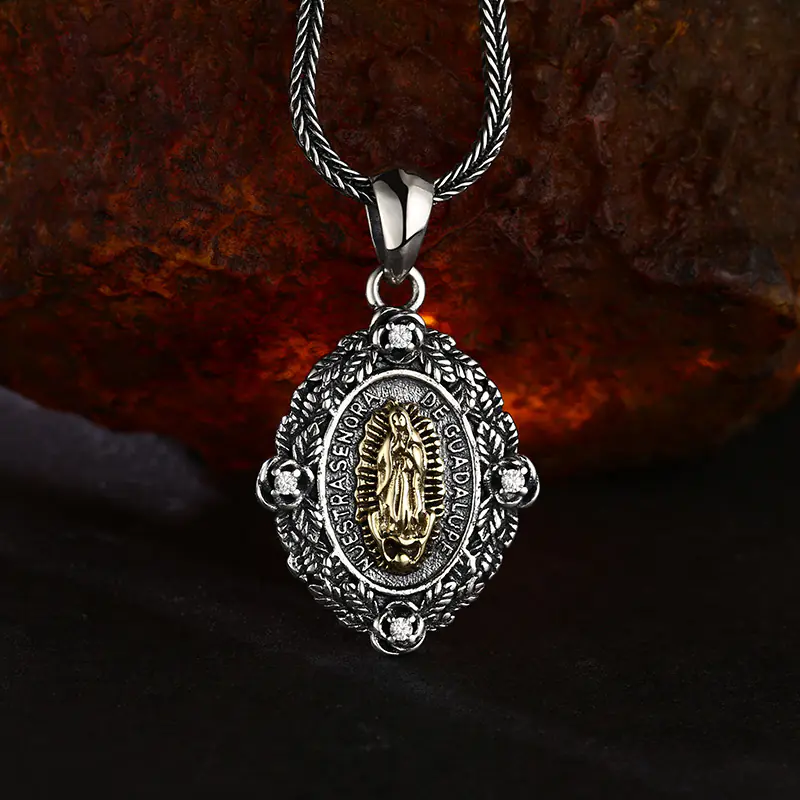 Antique oxidized two‑tone 925 sterling silver Our Lady of Guadalupe oval medal pendant, religious amulet with rose stone border, moody rough rock background