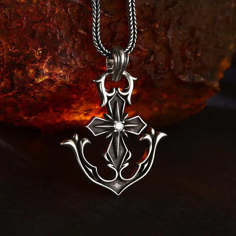 Slight side‑angle view oxidized 925 silver anchor cross pendant, showcasing relief scroll carvings and central set stone