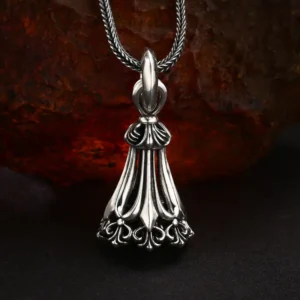 Front full view vintage filigree 925 sterling silver tassel bell pendant, antique oxidized finish, ornate floral hollow carving on rough rust rock background
