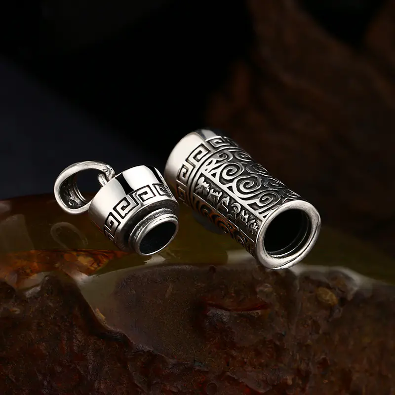 3-925‑silver‑gau‑box‑prayer‑cylinder‑pendant‑screw‑open‑hollow‑interior‑detail‑shot.jpg Close‑up of openable screw‑top 925 silver gau box prayer cylinder pendant, hollow interior storage space, removable screw cap with traditional pattern engraving
