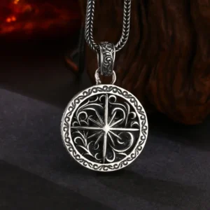 Front lifestyle view 925 sterling silver open‑work star compass medallion pendant, deep oxidized hollow carving against dark wood grain background