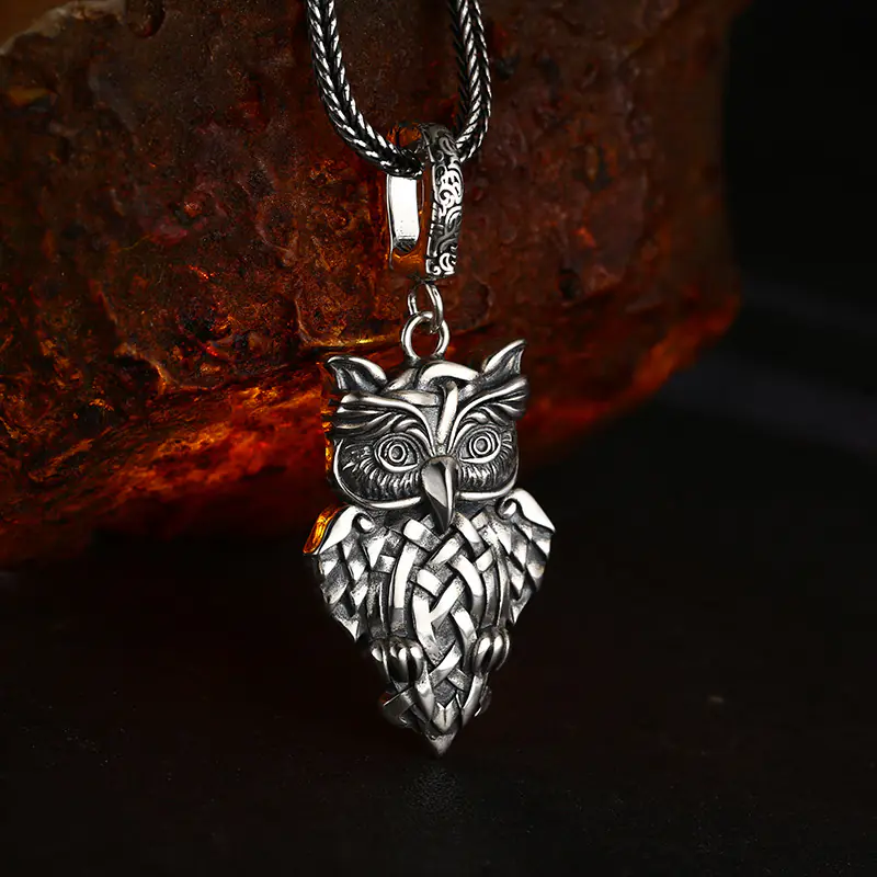 925 sterling silver celtic knot owl pendant displayed with wheat chain on rough stone