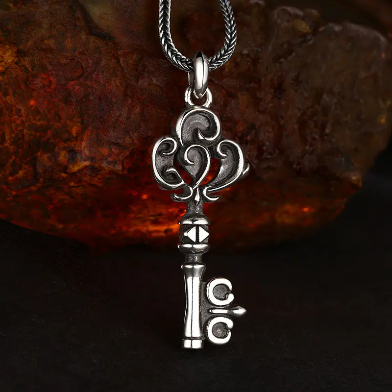 925 sterling silver scroll key pendant matched with wheat chain on rustic stone