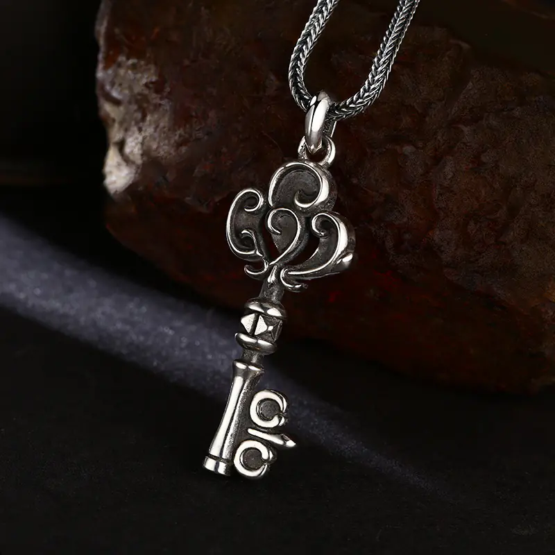 Angled view of vintage scroll pattern 925 sterling silver key pendant